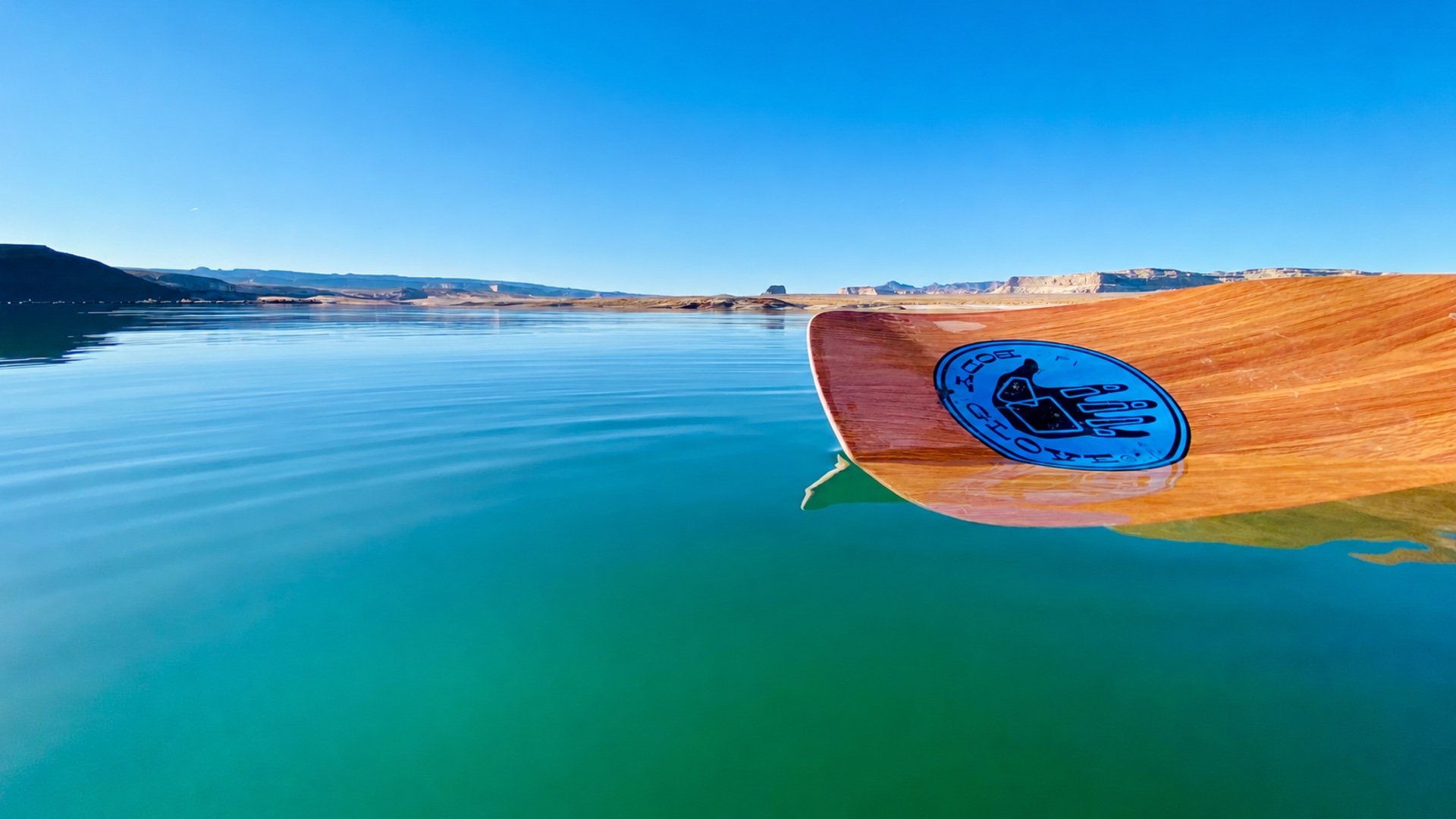 A Surf Inn board on still Lake Powell water