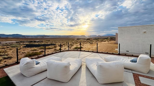 Outdoor lounge seating facing the desert at sunset